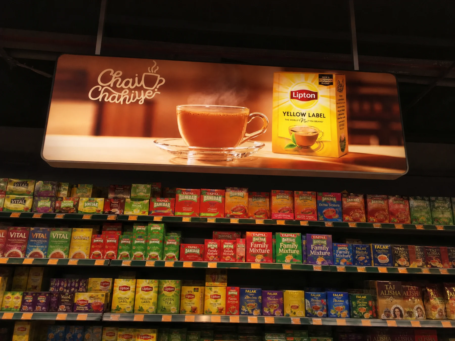 Ceiling-hung illuminated Lipton lightbox above the tea aisle at Al-Fatah