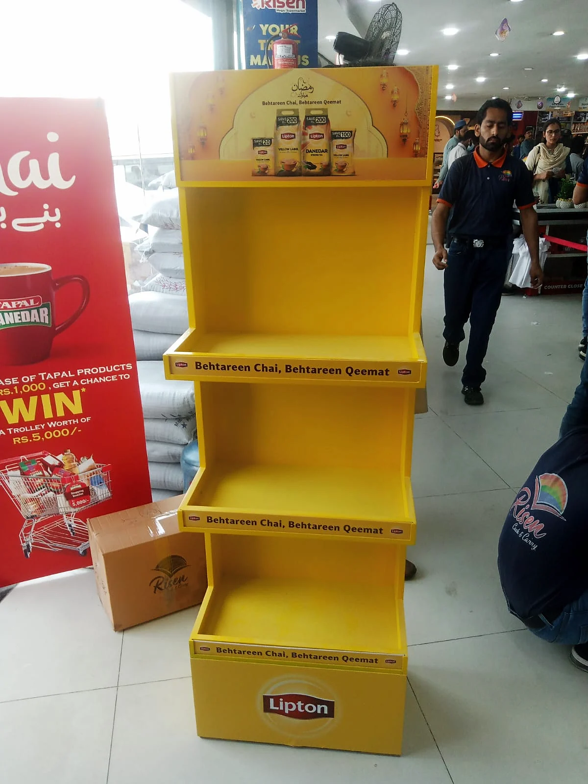 Lipton Ramzan unit on a modern-trade floor beside a competitor standee